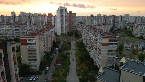 Aerial-view-over-a-street-between-old-soviet-apartment-buildings,-in-a-poverty-slum-area-of-Kyiv,-during-sunset,-in-Kiev,-Ukraine---dolly,-drone-shot