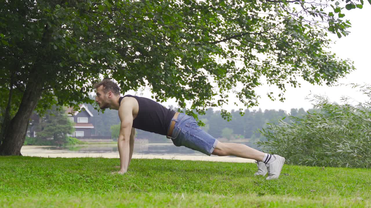 un atleta haciendo flexiones junto a un lago en la naturaleza.