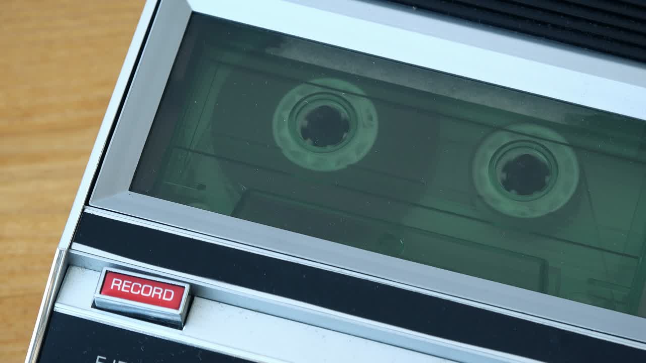 cinta de cassette de audio rodando en un reproductor de época