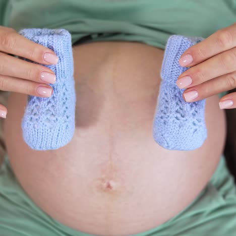 Close up of pregnant woman. View of pregnant woman holding baby bell