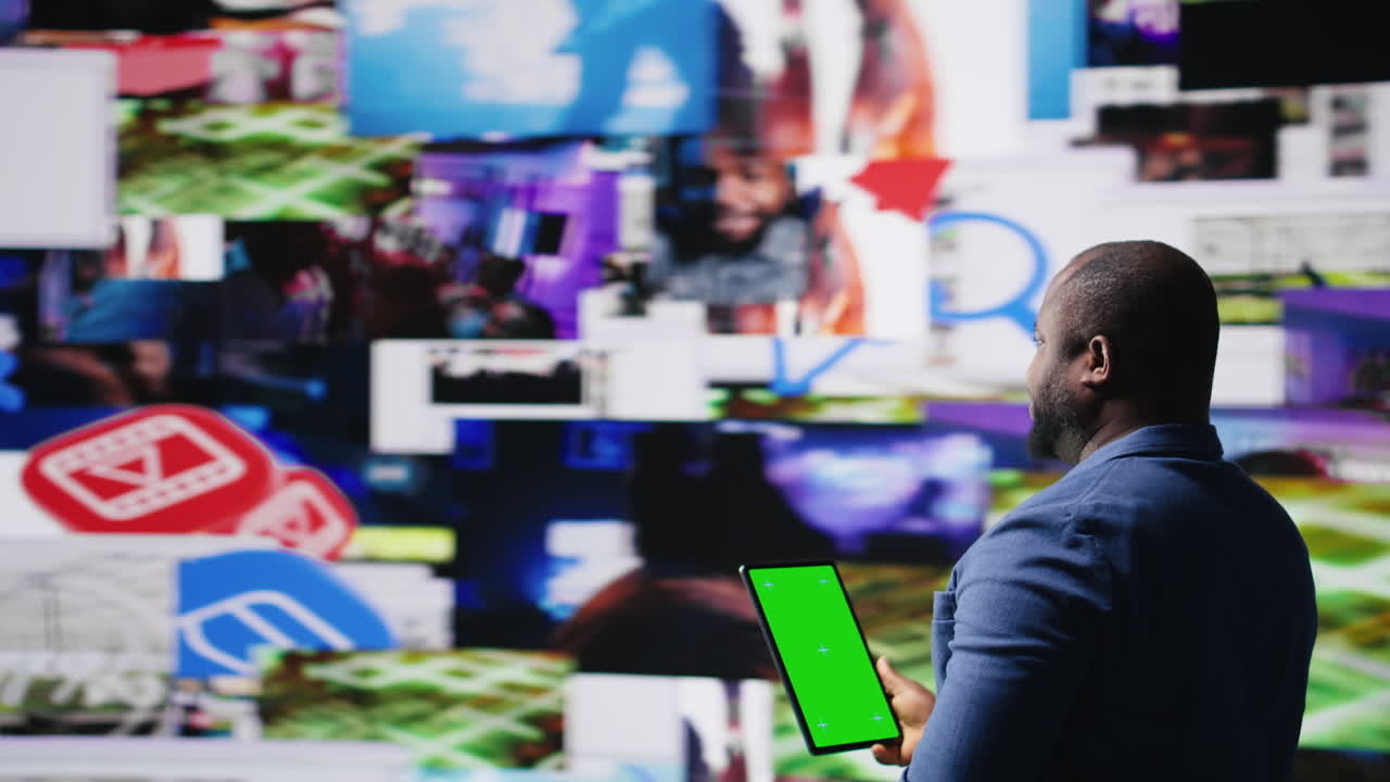 African American tech enthusiast looking at chroma key screen