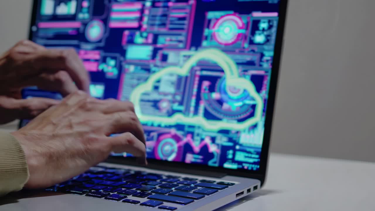 Close-up video of hands typing on a laptop keyboard. Side angle captures the focus on fingers