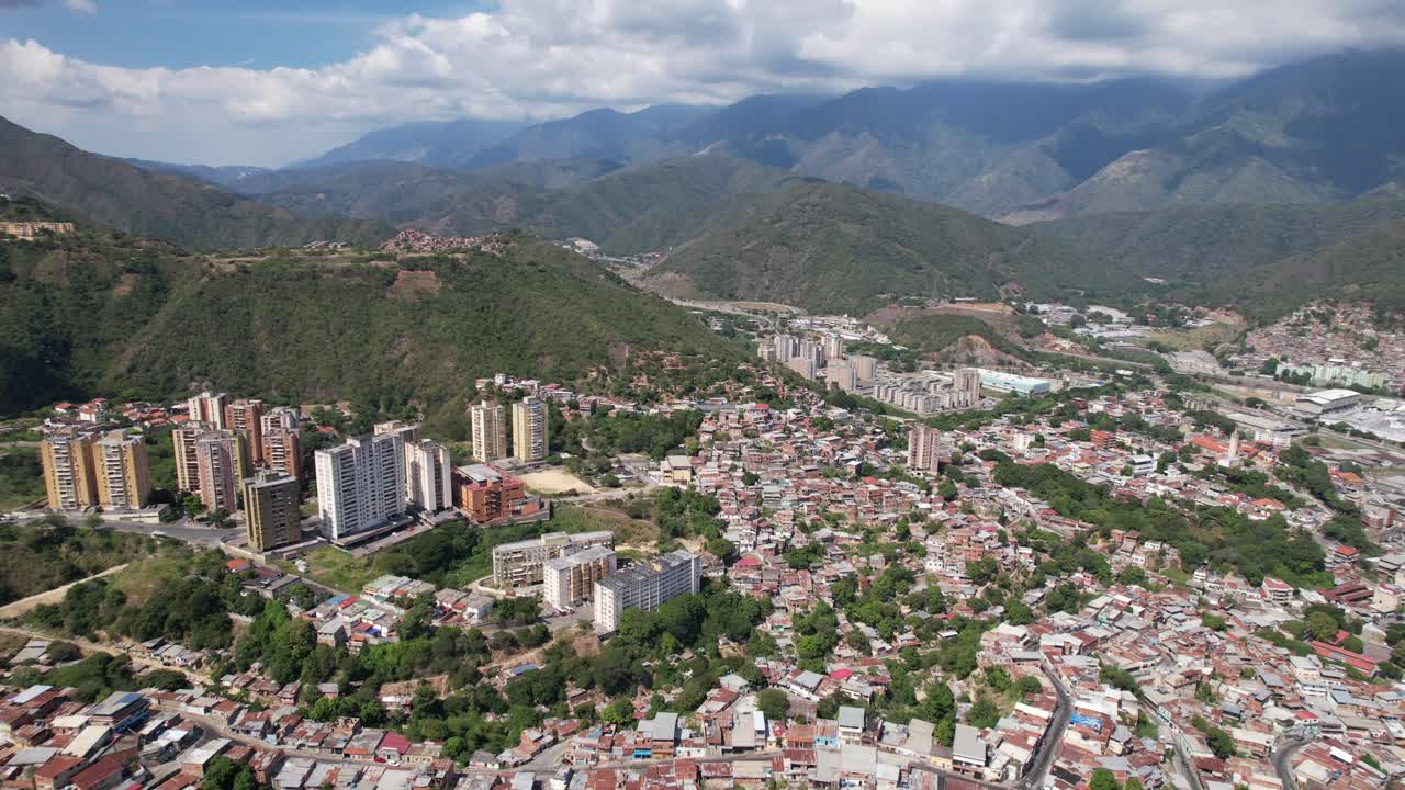 Guarenas, miranda, surrounded by lush green mountains on a sunny day, aerial view