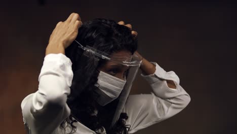 Profesional-Médico-Con-Mascarilla-Y-Escudo-Ajusta-El-Casco-Para-Una-Mejor-Protección-Contra-Un-Virus---Aislado