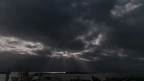 Schöner-Zeitraffer-Von-Wolken,-Die-Vor-Der-Sonne-Vorbeiziehen-Und-über-Ein-Ruhiges-Meer-Blicken