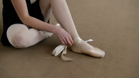 ballet dancer tying pointe shoes