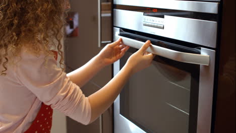 girl preparing food in oven