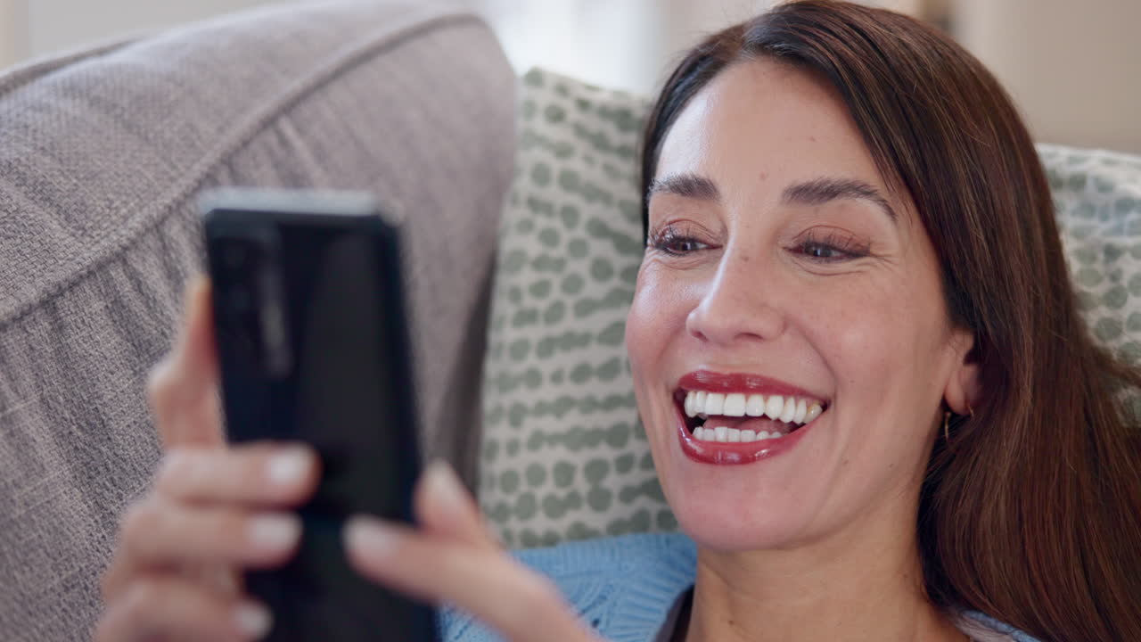 mujer riendo mientras mira su teléfono