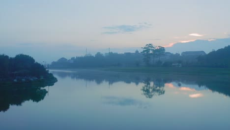 drone view of xuan huong lake in misty morning, reflection on the water