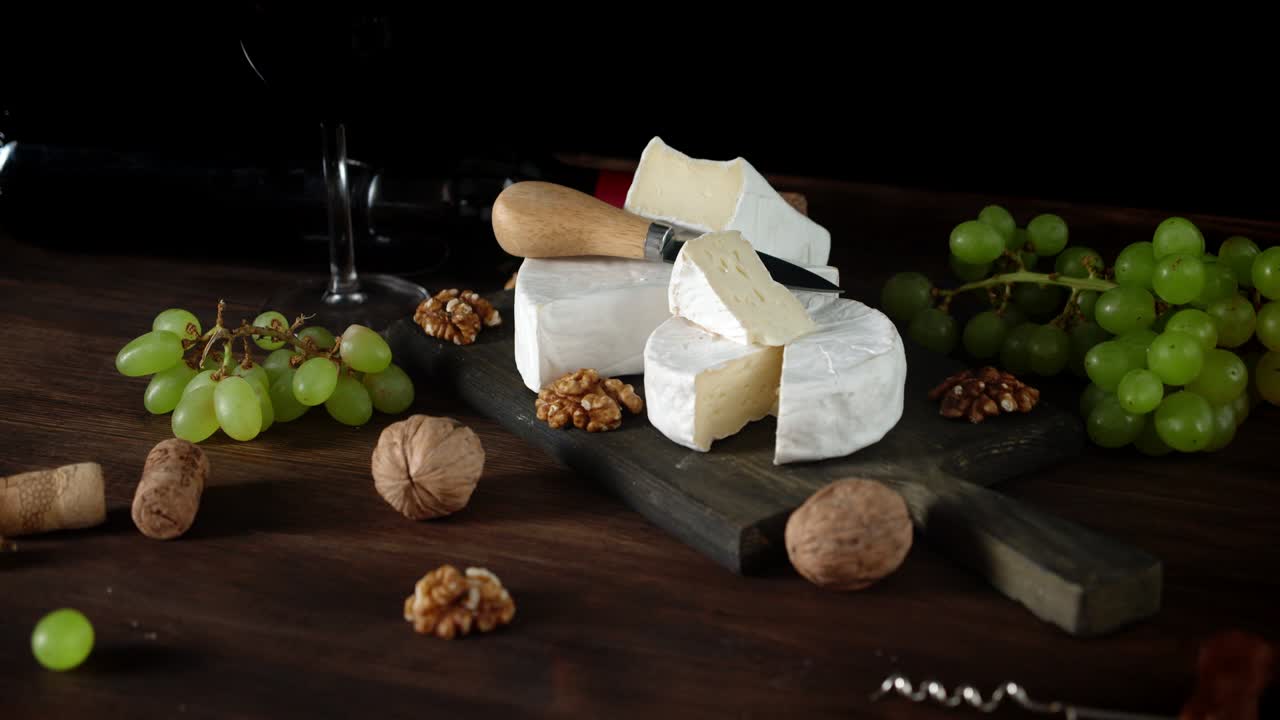 el queso camembert con nueces y uvas gira lentamente.