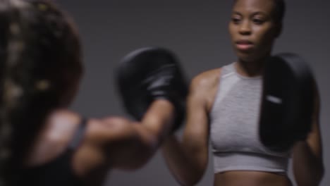 Studio-Shot-Of-Woman-Wearing-Boxing-Gloves-Sparring-With-Trainer-5