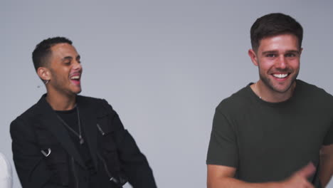 group studio portrait of multi-cultural male friends dancing in slow motion together