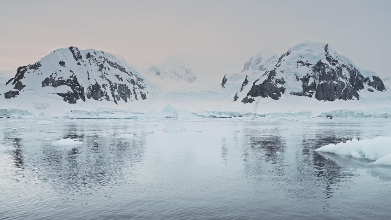 Antarctica Mountains Landscape at Sunset on Zodiac Boat Trip Tour Excursion in Dramatic Beautiful Coastal Scenery with Glacier and Sea Ice at Sunrise on Antarctic Peninsula Coast