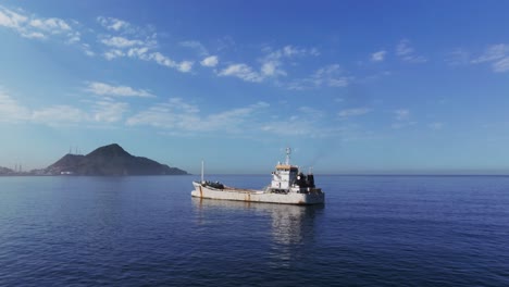 Frachtschiff-Schwimmt-Tagsüber-Im-Ruhigen-Blauen-Wasser-Des-Meeres