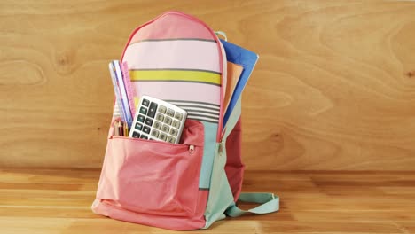 primer plano de la bolsa escolar con libros y artículos de papelería