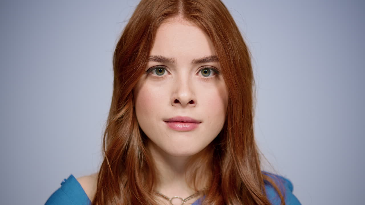 스튜디오에서 카메라를 보는 혼란스러운 소녀. 실내에서 포즈를 취하는 무관심한 여성