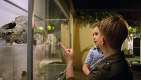 Mother-and-her-little-son-enjoying-a-natural-history-museum,-side-close-up-shot