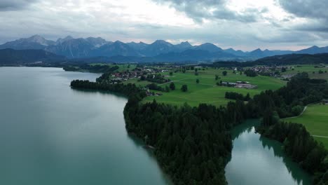 paisaje alrededor del forggensee bávaro con la cordillera de los alpes bajo las nubes por la noche