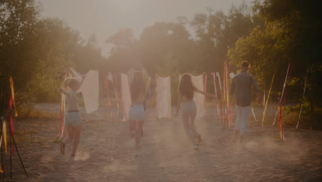 carefree young men and women running at beach