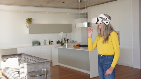 using vr headset, woman interacting with virtual environment in modern kitchen, at home, copy space
