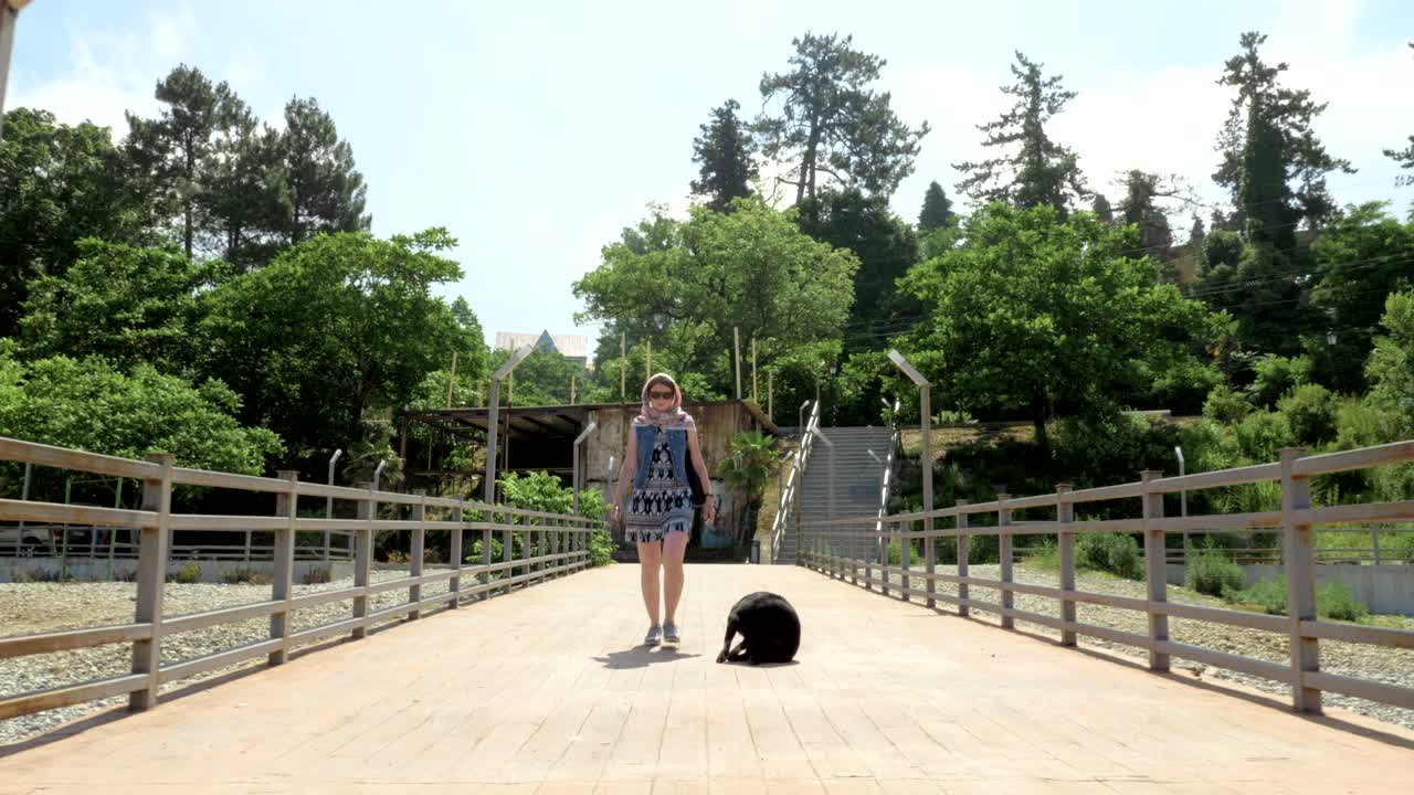 chica caminando con el perro pequeño y gracioso en el muelle. batumi, georgia