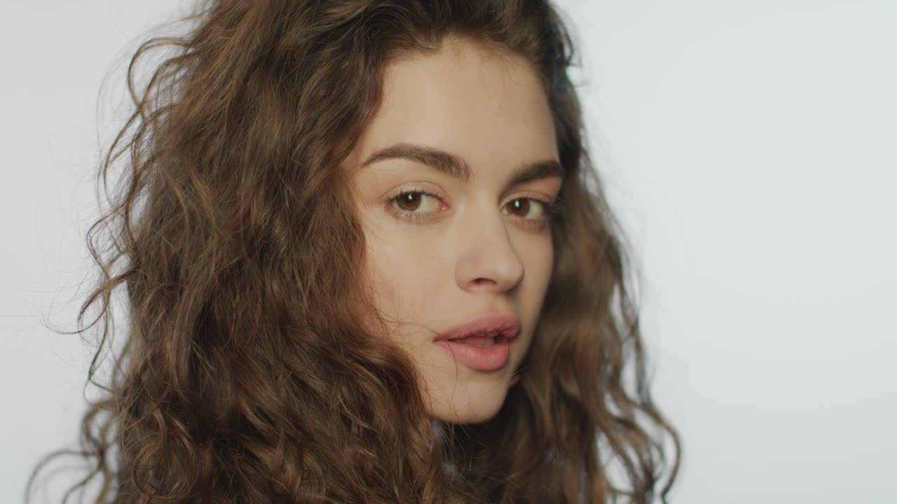 cara de mujer atractiva en fondo blanco. chica juguetona mirando a la cámara