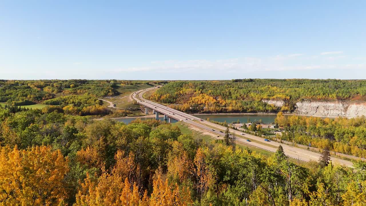 Aerial View Of Trees With Saskatchewan River In Autumn With cars driver over Devon Bridge