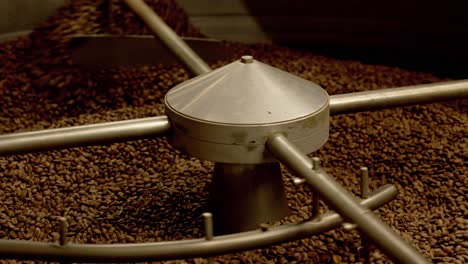 deliciosos granos de café marrones calientes girados y tostados en una máquina