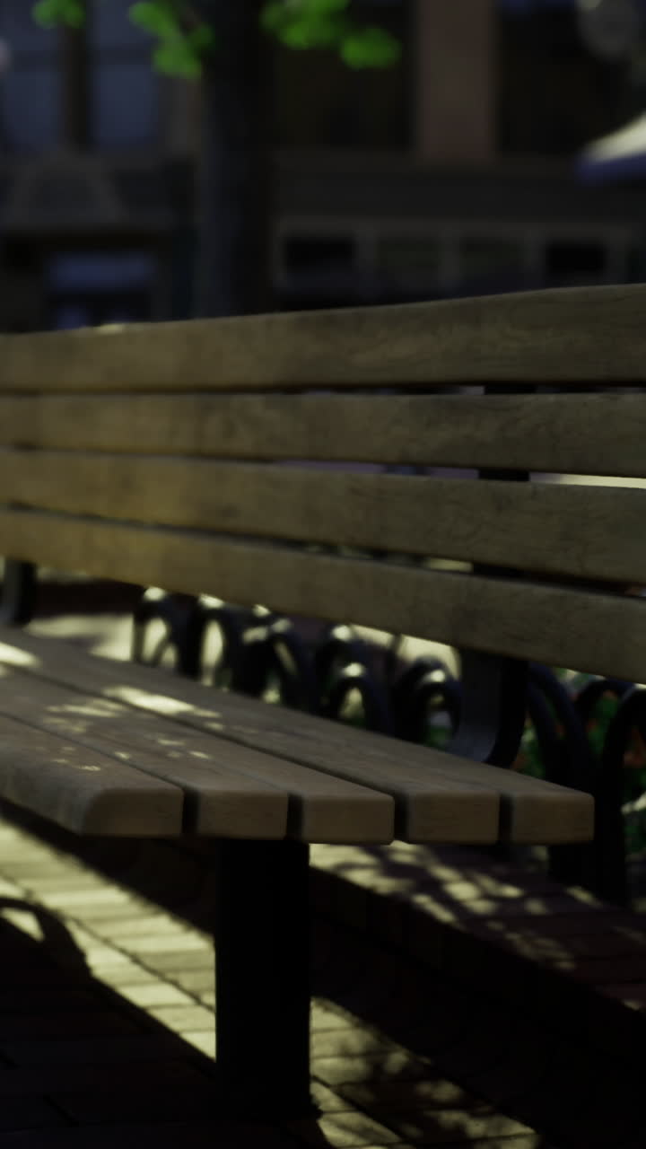 Empty wooden bench in a quiet urban plaza during golden hour