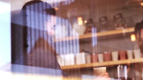 Waiter-serving-a-glass-of-cold-coffee-to-customer-at-counter