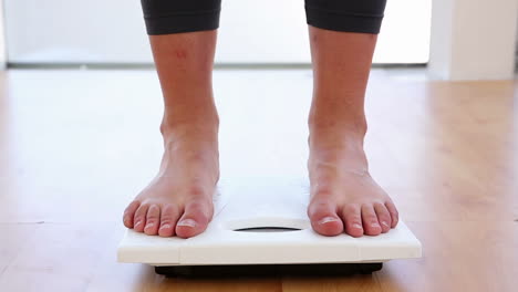 woman stepping on scales