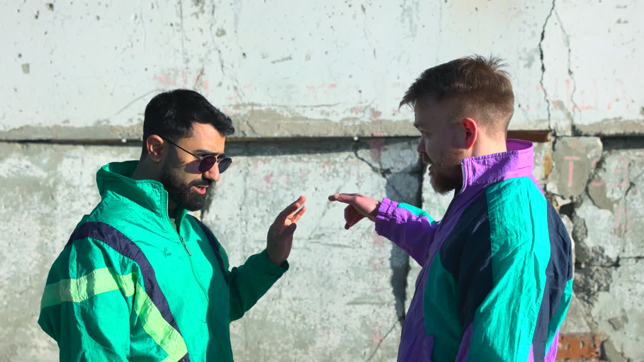 Two Men White And Asian Resolving Dispute Near Cracked Concrete Wall, Mediator Calming Friend With Measured