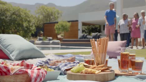 Fröhliche,-Vielfältige-ältere-Freunde,-Die-Unverändert-In-Zeitlupe-Zum-Picknick-Im-Sonnigen-Garten-Gehen