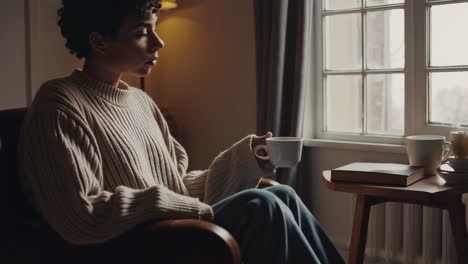 woman relaxing by the window with coffee