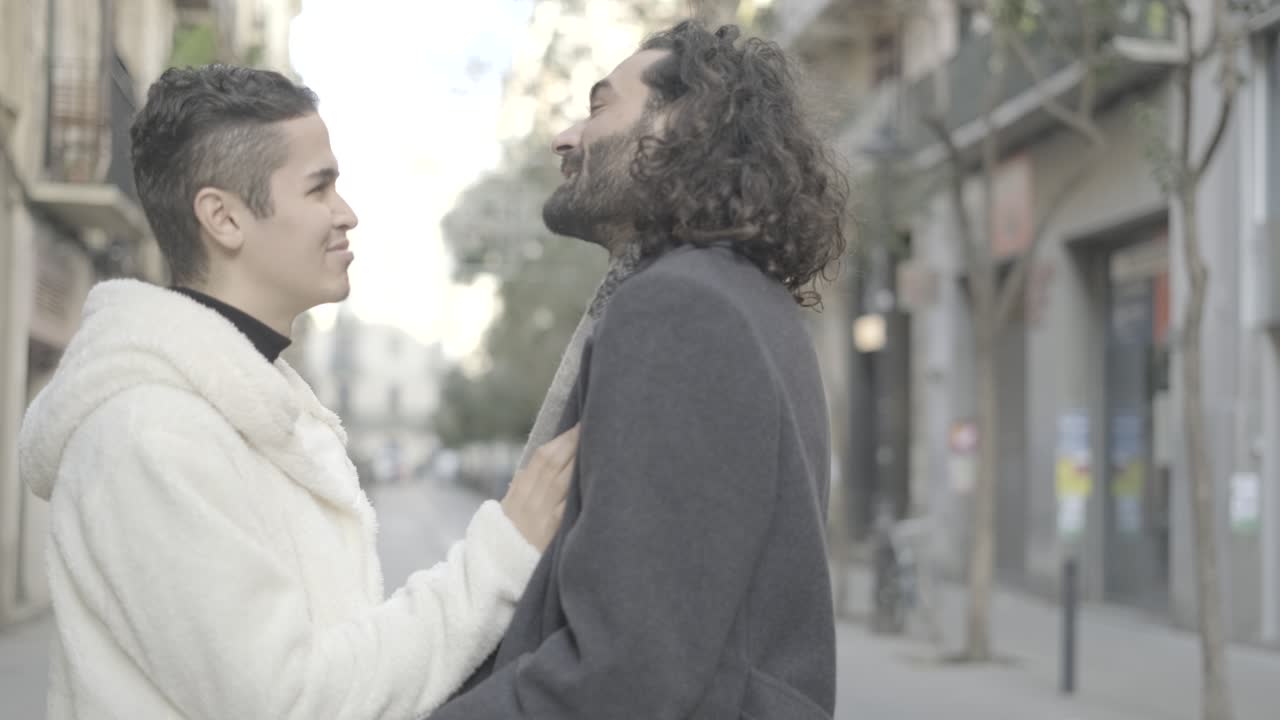 Dos personas abrazándose y riendo en la ciudad
