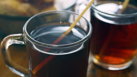 two mugs of hot tea on a wooden table