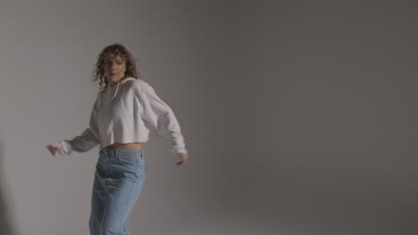 studio shot of young woman having fun dancing against grey background 5