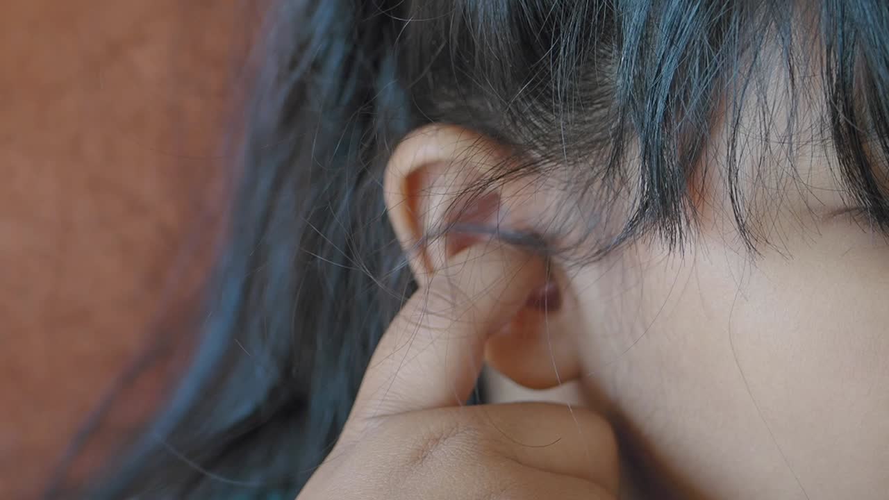 una mujer limpiándose la oreja