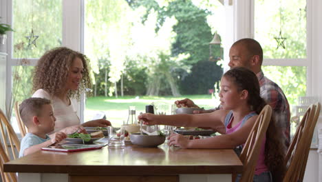 family at home eating meal in dining room together