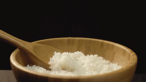 steamed rice in wooden bowl with spoon