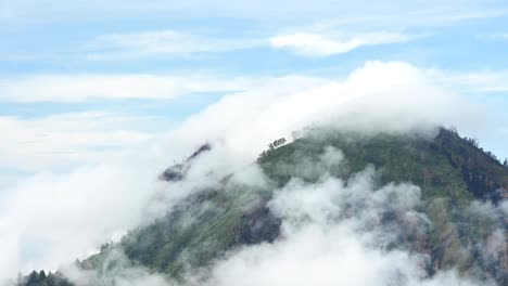 time lapse video of a mountain surrounded by clouds during sunrise in the ijen volcano complex.