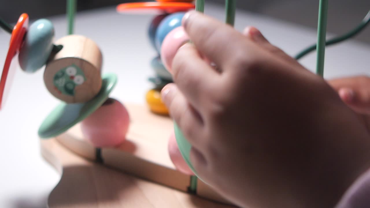 Bambino che gioca con un labirinto di perline in legno
