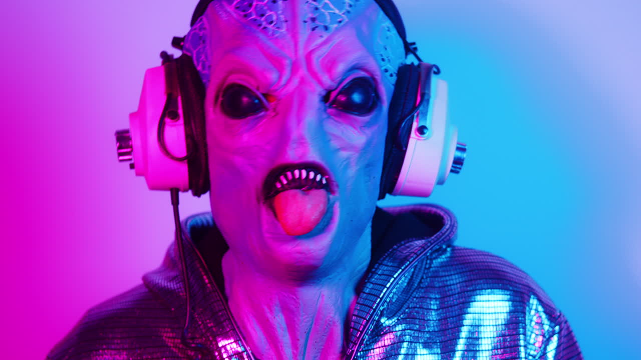Alieno con le cuffie che tira fuori la lingua sotto luci al neon.