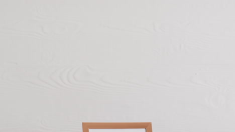 marco de madera con espacio de copia sobre fondo blanco y pared blanca