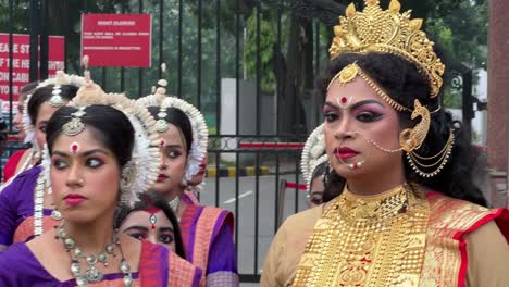 closeup shot of face of women dressed and make up as durga maa during evening in red road of kolkata, india.
