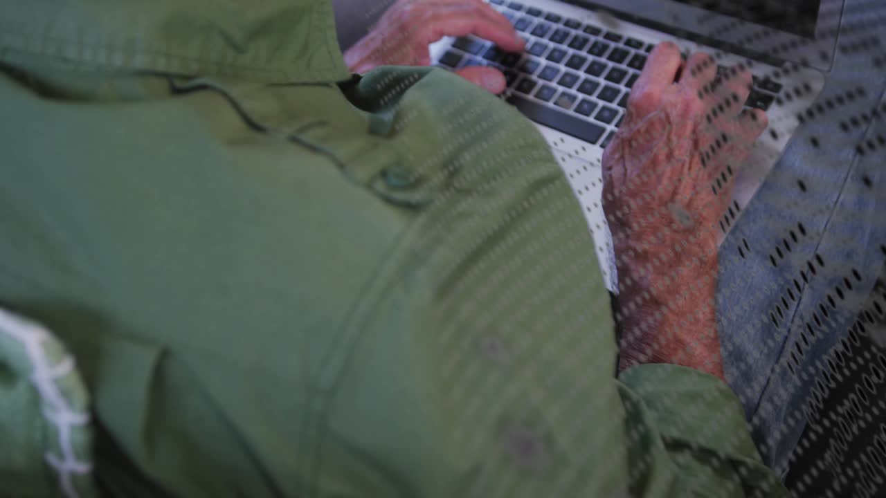 Ældre mand taster og browser på bærbar computer, hans hånd rører trackpad'en, hvilket får et gitter-overlay til at skifte for teknologi.