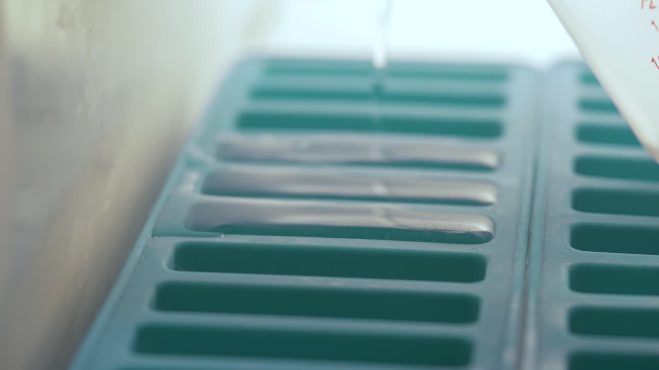 Acqua versata in uno stampo per ghiaccio flessibile in silicone
