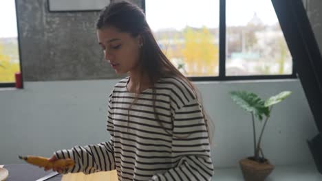 mujer comiendo plátano en una cocina moderna