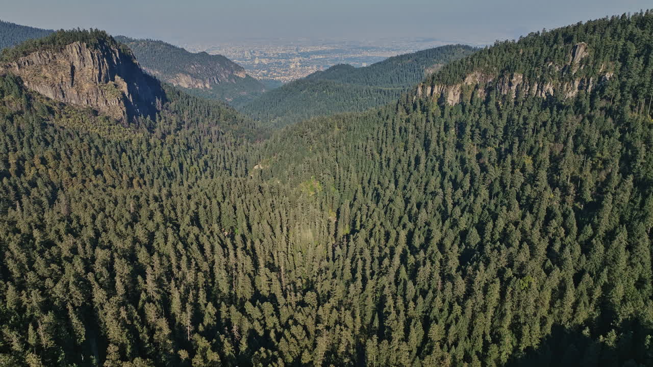ciudad de méxico aérea v98 disparo de elevación drone capturando hermoso paisaje montañoso cubierto de bosque de coníferas siempre verde con paisaje urbano en el fondo de la distancia - filmado con mavic 3 cine - enero de 2022