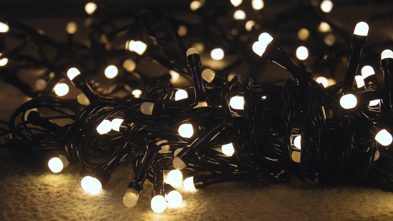 Nærbillede af juleguirlande med gyldne lys på et plaid. Julekoncept. Boligindretning